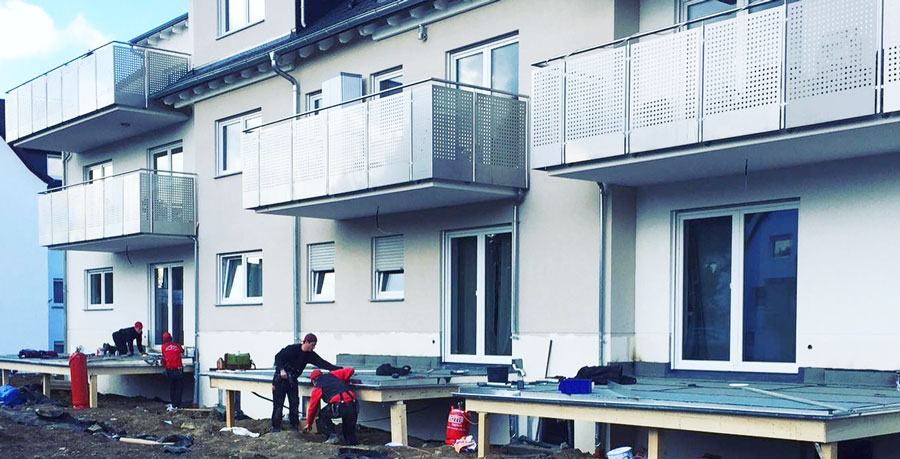 Männer arbeiten am Terrassenbau für ein neues Mehrfamilienhaus